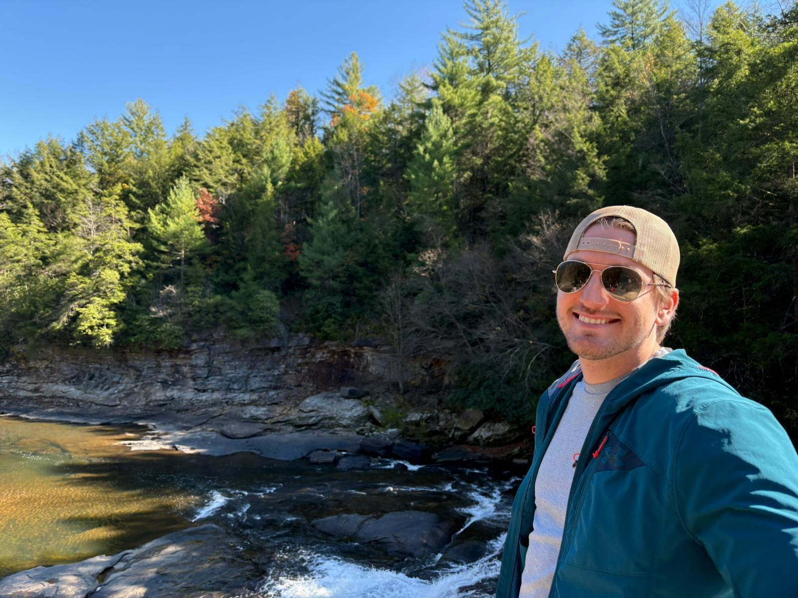 Nicholas in sunglasses in front of a small water feature